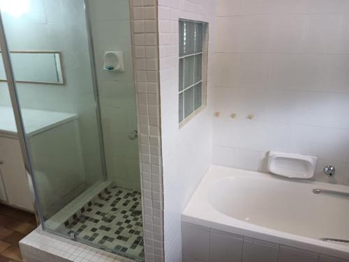 a white bathroom with a shower and a sink at Pennington Holiday Cottages in Pennington
