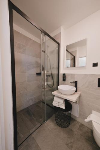 a bathroom with a glass shower and a sink at Pannolio Beach Boutique Apartment in Eisenstadt