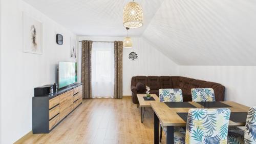 a living room with a couch and a table at Dębówka - apartament rodzinny in Wilcze