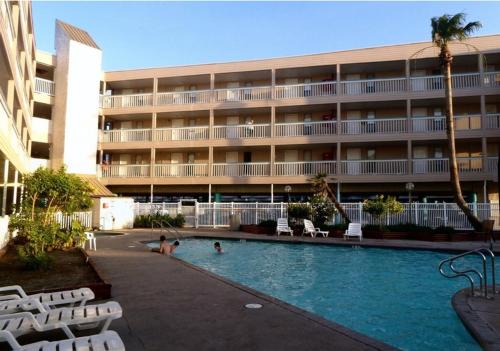 a hotel with a swimming pool in front of a building at Spectacular Beach View! in Corpus Christi