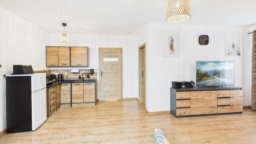a kitchen with a black and white refrigerator at Dębówka - apartament rodzinny in Wilcze