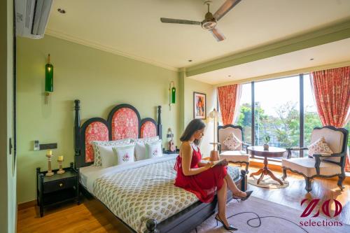 a woman sitting on a bed in a room at Zo Selections Jaipur by Zostel in Jaipur