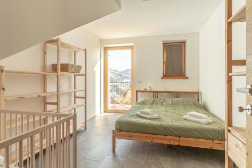a bedroom with a bed and a staircase and a window at Nest Love, Bedollo Ospitar in Bedollo