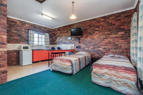 a room with a bed, a table and a window at Fernvale Hotel Motel in Fernvale