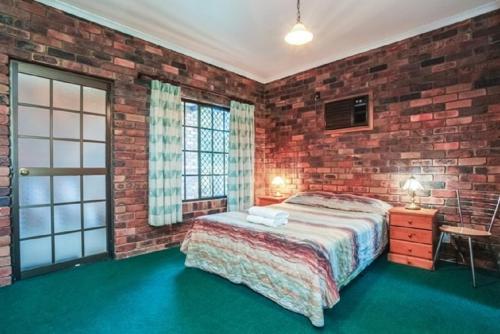 a bedroom with a large bed and a large window at Fernvale Hotel Motel in Fernvale
