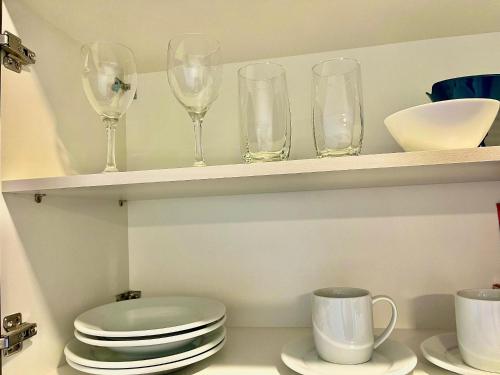 a shelf with wine glasses and plates on it at Loft near Santa Casa - Apt 604 in Porto Alegre
