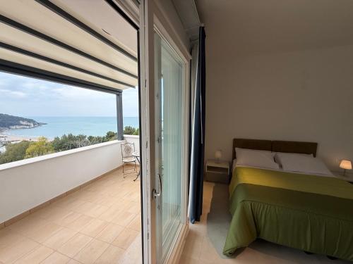 a bedroom with a bed and a view of the ocean at Suites Prestige in Peschici