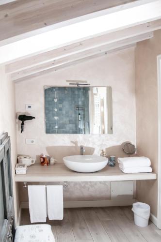a white bathroom with a sink and a mirror at B&B La Fiaba in Sirmione