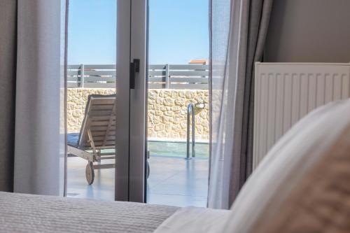 a bedroom with a sliding glass door to a balcony at Azure Harmony Pool Villa by SEM in Áyios Spirídhon