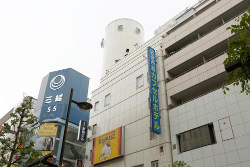 a building with a sign on the side of it at Shinjuku Kuyakusho-mae Capsule Hotel in Tokyo