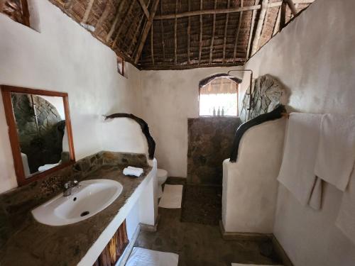 a bathroom with a sink and a mirror at Lemara Eco Camp in Kisaki