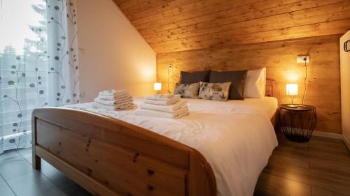 a bedroom with a large white bed with wooden walls at Casa Foresta by Villas Guide in Mrkopalj