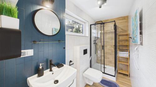 a bathroom with a sink and a toilet and a mirror at Dębówka in Wilcze