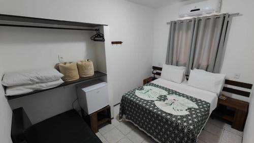 a small room with a bed and a desk at Pousada Barcelos in São Roque de Minas