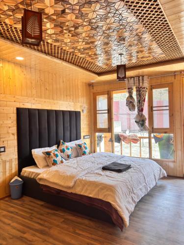 a bedroom with a large bed with a black headboard at Dream River Resort in Batakūt