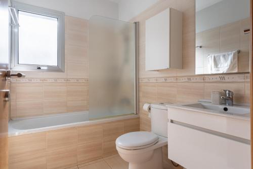 a bathroom with a toilet and a sink and a shower at Relaxing 2BDR Retreat in Protaras in Paralimni