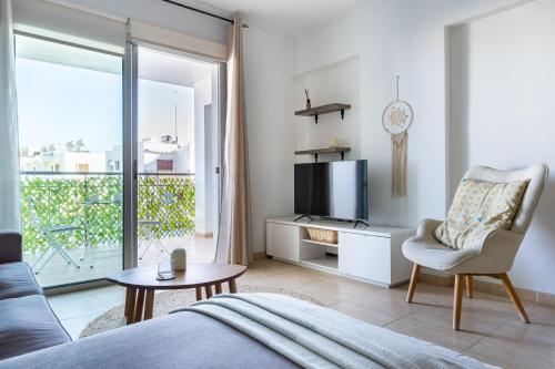 a living room with a couch and a tv at Relaxing 2BDR Retreat in Protaras in Paralimni