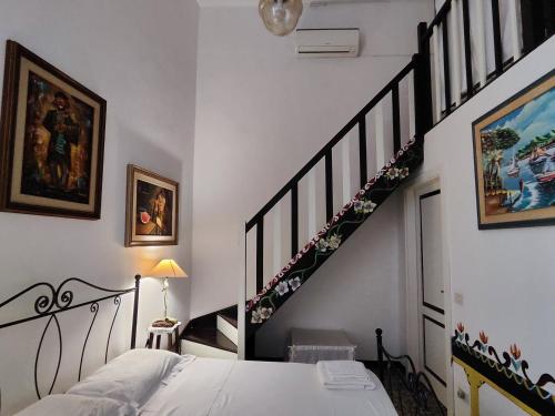 a bedroom with a bed and a spiral staircase at B&B Palazzo Antonelli in Monopoli
