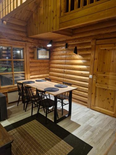 ein hölzerner Raum mit einem Tisch und Stühlen in der Unterkunft Himoskoti in Jämsä