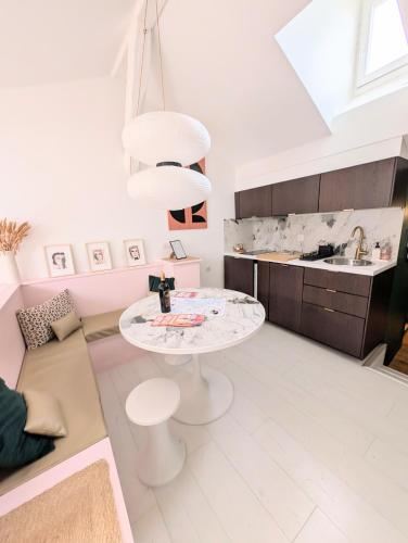 a kitchen with a white table in a room at Charmant cocon sous les toits de Bordeaux in Bordeaux