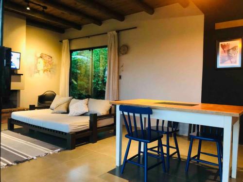 a living room with a bed and a bar with stools at Casa Morro da Borússia in Osório