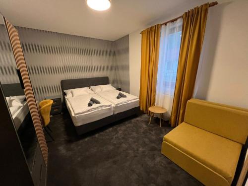 a bedroom with a bed and a chair and a window at Kormorán Vendégház in Matty
