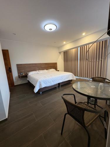 a bedroom with a bed and a table and chairs at Hotel Zaniah in Huancayo
