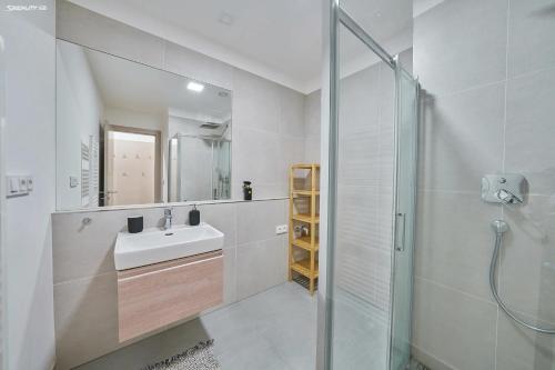 a white bathroom with a sink and a shower at Dolce Vita Harrachov in Harrachov