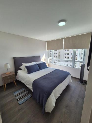 a bedroom with a large bed and a window at Apartment in Playa Brava Ocean View & SmartLock in Iquique
