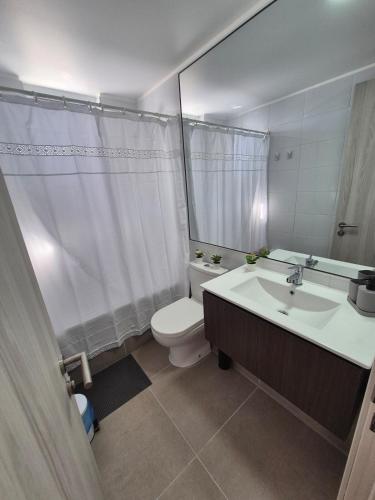 a bathroom with a sink and a toilet and a mirror at Apartment in Playa Brava Ocean View & SmartLock in Iquique