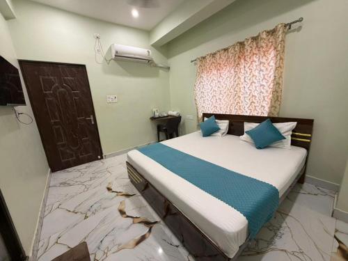 a bedroom with a large bed with blue pillows at Jogi Lodge in Varanasi