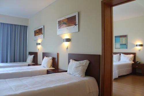 a hotel room with two beds and a mirror at Hotel Dom Afonso - Monção in Monção