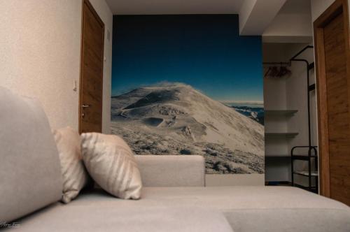 a bedroom with a mountain mural on the wall at Cabana Valea Lupilor in Straja