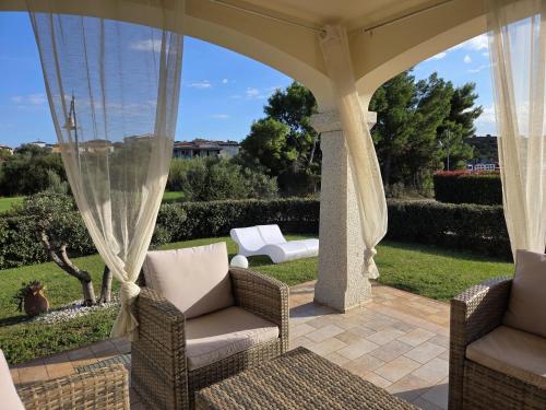 a patio with two chairs and a gazebo at Casa Nala - Villa con giardino in Budoni