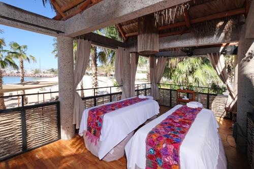two beds in a room with a view of the ocean at Hotel Indigo La Paz Puerta Cortes by IHG in La Paz