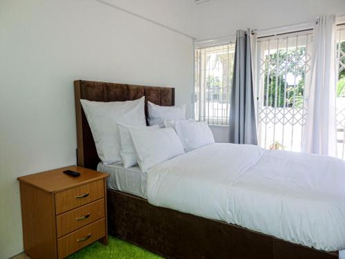 a bedroom with a large bed with white sheets and pillows at Durbanville Queens and Kings Guest House in Cape Town