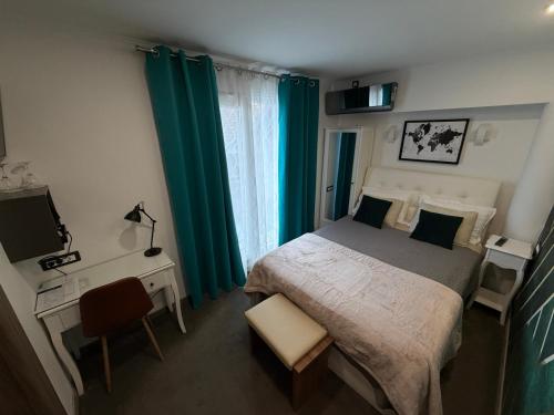 a bedroom with a bed and a desk with a television at Luxury rooms Lira in Ogulin