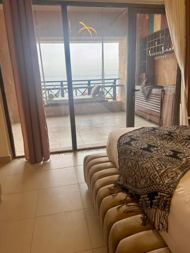 a bedroom with a bed and a view of the ocean at Samarah EP 04 full Sea View and poll access prime location with big terrace, in Sowayma