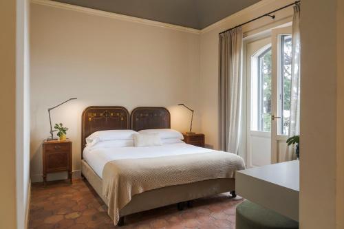 a bedroom with a large bed and a window at Wine Resort Villagrande in Milo