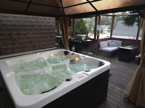 a jacuzzi tub sitting on top of a deck at Hot Tub A-Frame Cabin Lake Arrowhead Escape in Rimforest