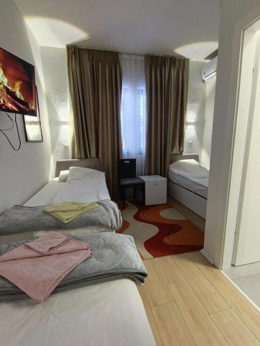 a hotel room with two beds and a window at Travel Hub Hostel Social and Friendly in Ohrid