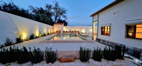 a swimming pool in the backyard of a house at Casa da Ti Maria Vieira in Santa Clara-a-Velha