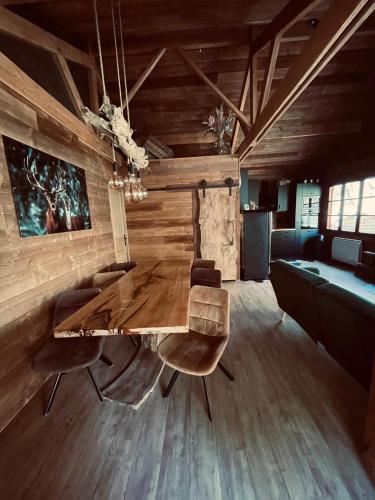 a dining room with a wooden table and chairs at Auvers Wood lodge in Auvers-sur-Oise