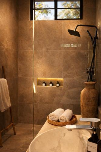 a bathroom with a sink and a glass shower at Oran Villa Bali in Tampaksiring