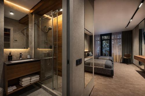 a bathroom with a shower and a sink and a bed at Wood Hotel Resort & SPA in Bukovel