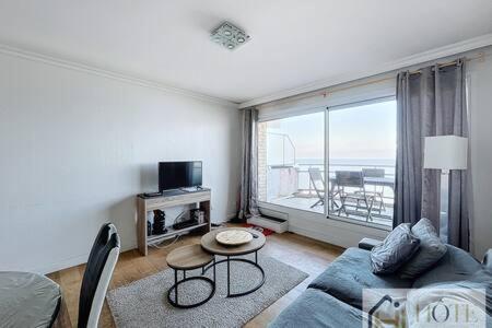 a living room with a couch and a table at Le Panoramique Marin- 2Ch in Bray-Dunes