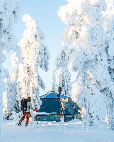 a woman standing in front of a tent in the snow at Syöte Igloos in Syöte