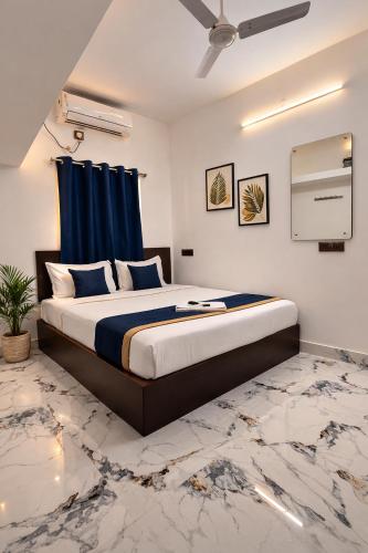 a bedroom with a large bed with a blue curtain at Hotel Rhythms Residency in Chennai