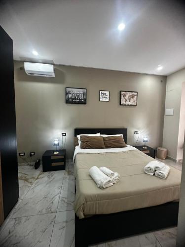 a bedroom with a large bed with towels on it at Little Dreams in Caserta
