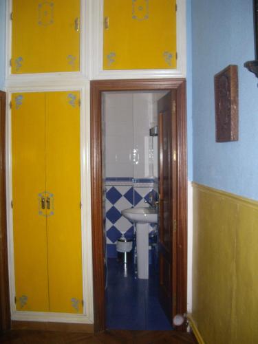 a bathroom with yellow doors and a sink at Hostal Pacios in Madrid